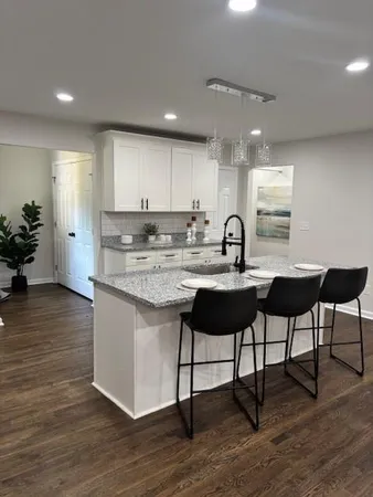 a kitchen with a sink cabinets and wooden floor