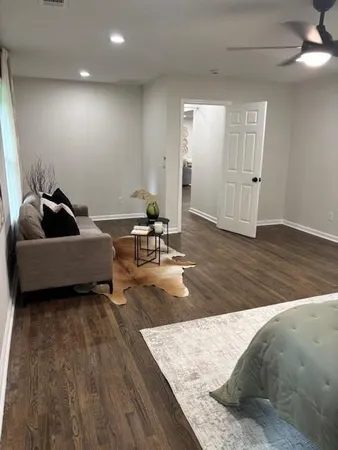 a living room with furniture and a wooden floor