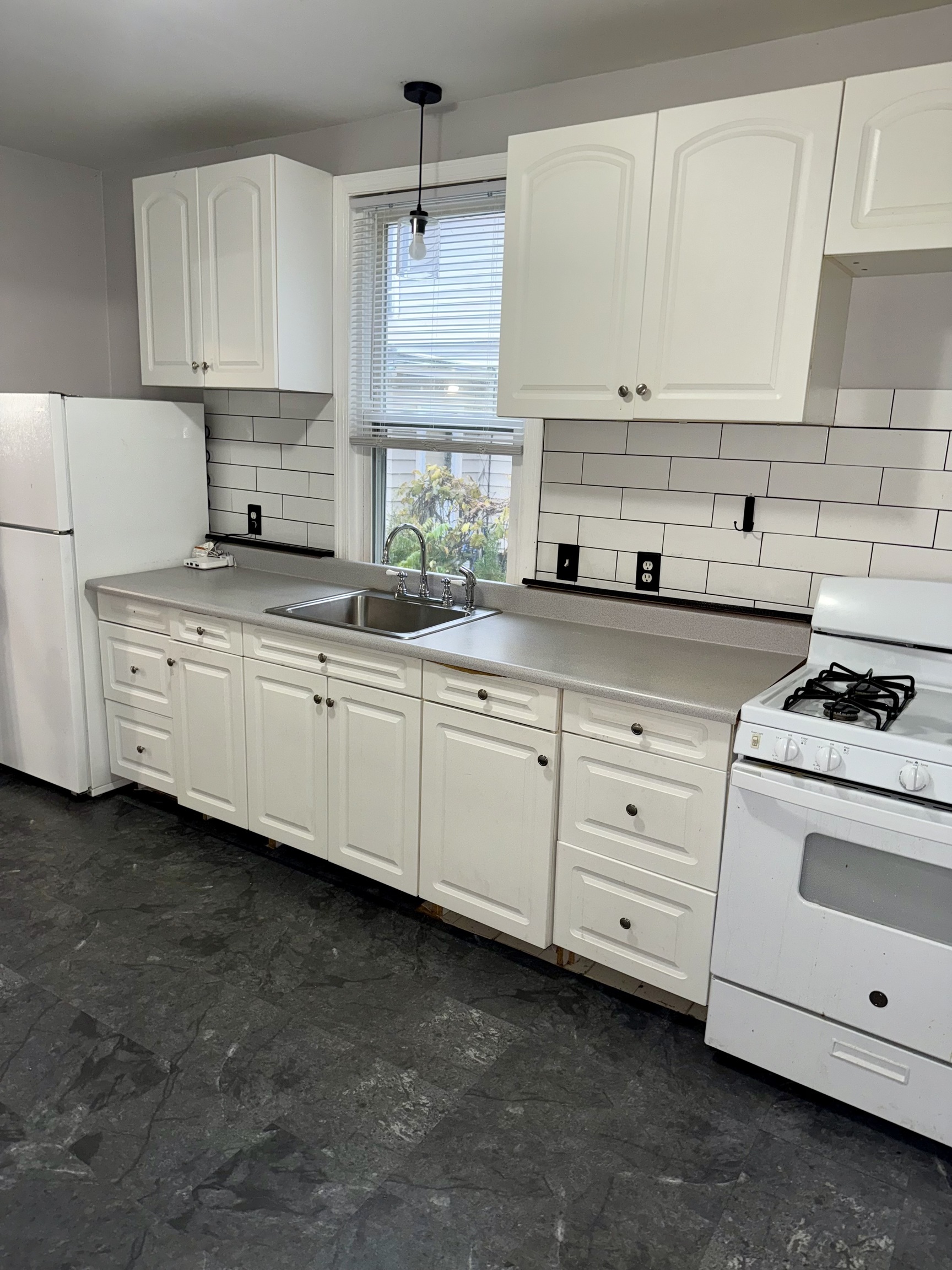 74 Mt Pleasant Street, Unit 1 Derby, CT 06418 - Photo 6 of 11 a kitchen with granite countertop white cabinets and white appliances