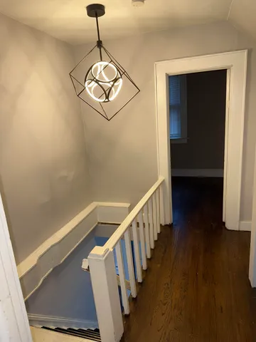 a view of a hallway with wooden floor and stairs