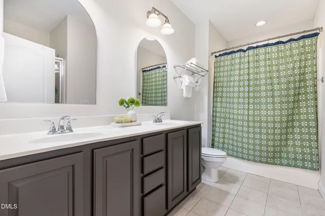 a bathroom with a double vanity sink toilet and a mirror