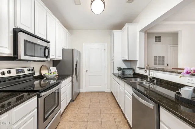 a kitchen with stainless steel appliances granite countertop a stove sink and cabinets