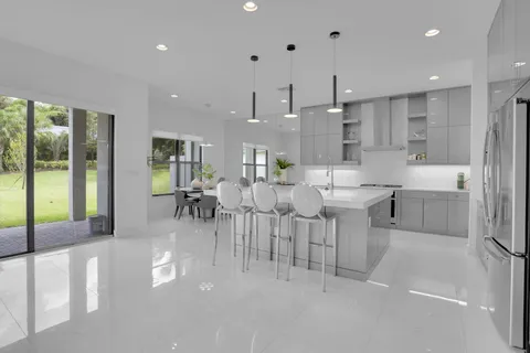 a kitchen with stainless steel appliances granite countertop a sink a stove and a wooden floors