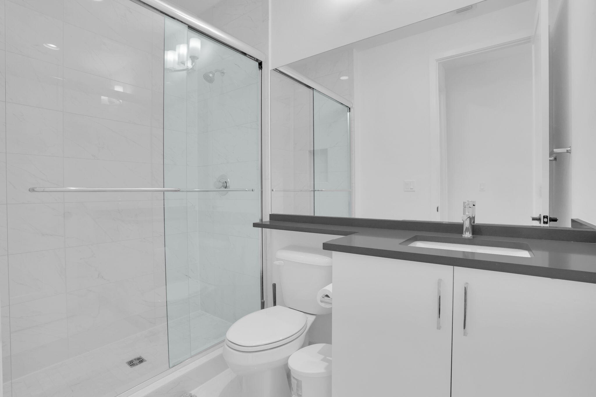 8115 Laurel Falls Drive Boca Raton, FL 33496 - Photo 42 of 74 a bathroom with a granite countertop sink a toilet and shower