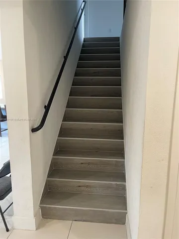 a view of staircase with lots of frames on wall