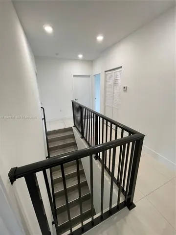 a view of staircase with lots of frames on wall
