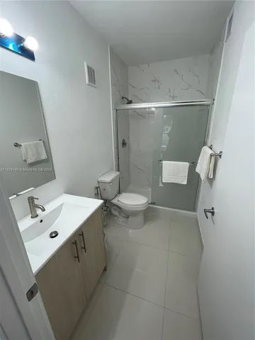 a bathroom with a sink mirror and toilet