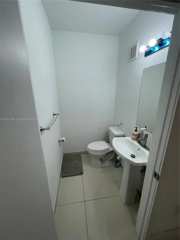 a bathroom with a sink mirror and toilet