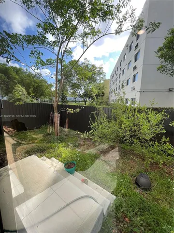 a view of a backyard with plants and a lake view
