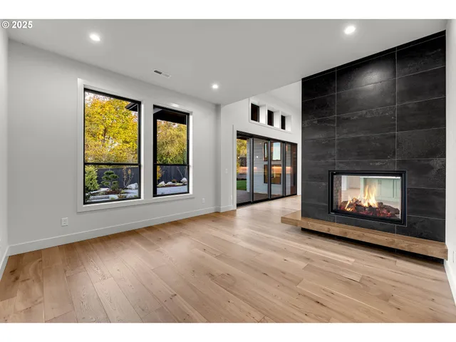 a view of an empty room with a fireplace and a window