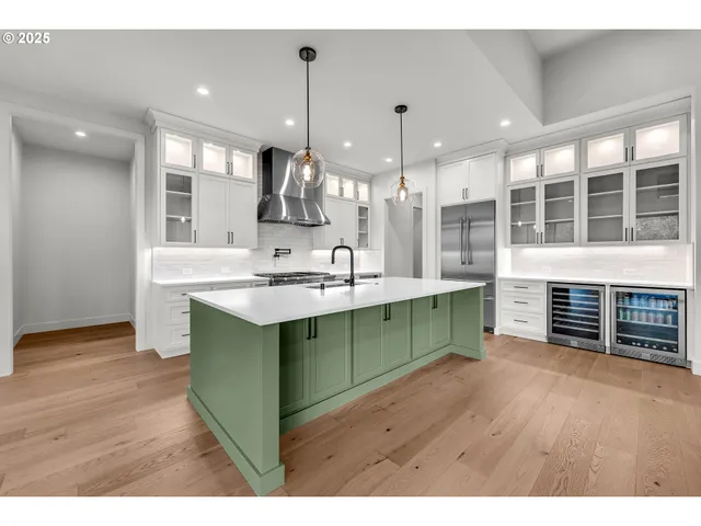 a kitchen with stainless steel appliances kitchen island a cabinets and a wooden floor