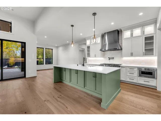 a kitchen with kitchen island granite countertop a sink counter top space appliances and cabinets