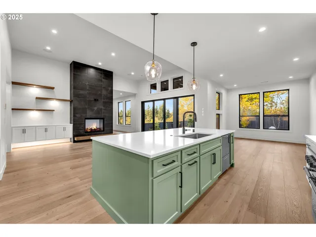 a kitchen with kitchen island granite countertop a stove and a wooden floors