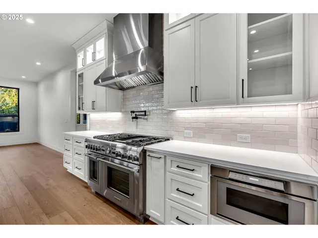 a kitchen with stainless steel appliances a stove a sink and a microwave