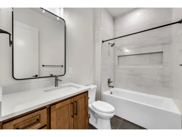 a bathroom with a granite countertop sink a toilet and shower