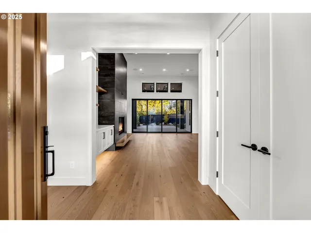 a view of a hallway with wooden floor and living room