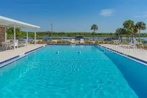 a view of a lake with a yard and large trees