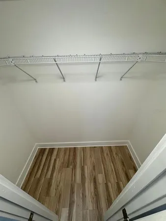 a view of a hallway with furniture and wooden floor