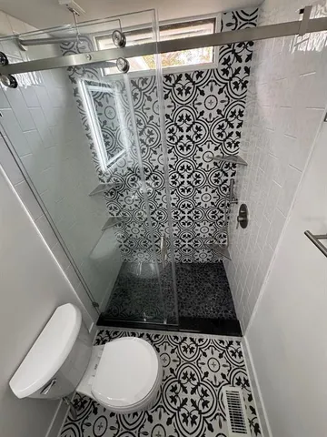 a bathroom with a toilet and a shower