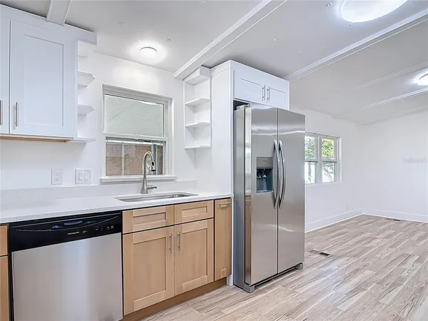 a kitchen with a sink a refrigerator and cabinets