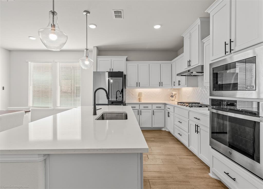 1213 Haggetts Pond Road Forney, TX 75126 - Photo 13 of 30 a kitchen with kitchen island white cabinets stainless steel appliances and a window