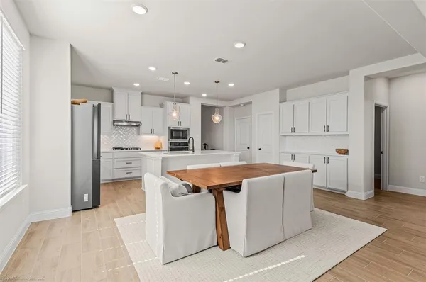 a large kitchen with stainless steel appliances and a refrigerator