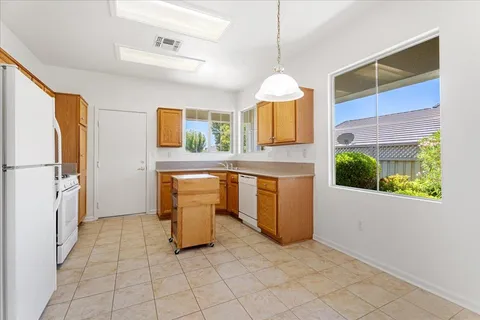a kitchen with stainless steel appliances granite countertop a stove a sink and a refrigerator