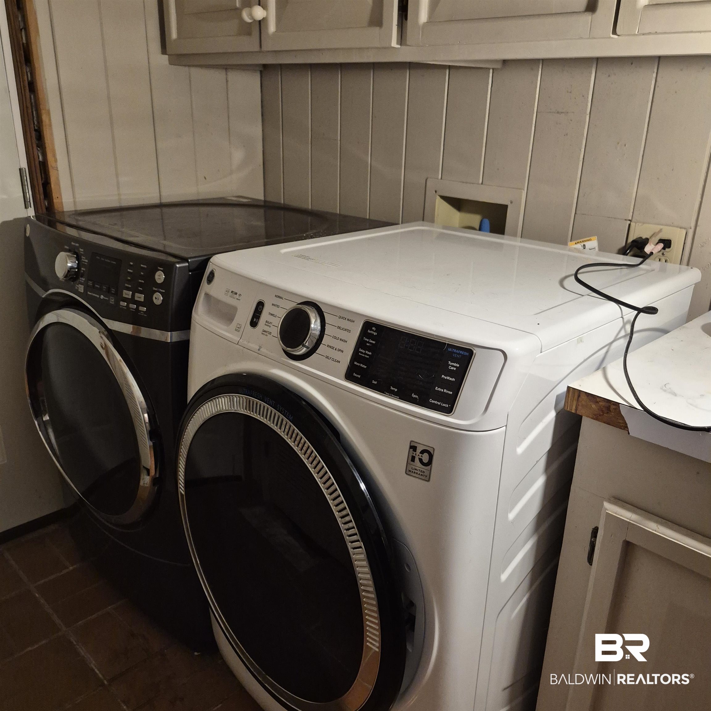 308 Rural Street Evergreen, AL 36401 - Photo 33 of 40 Laundry room with washing machine and dryer, cabinet space, and dark tile patterned flooring
