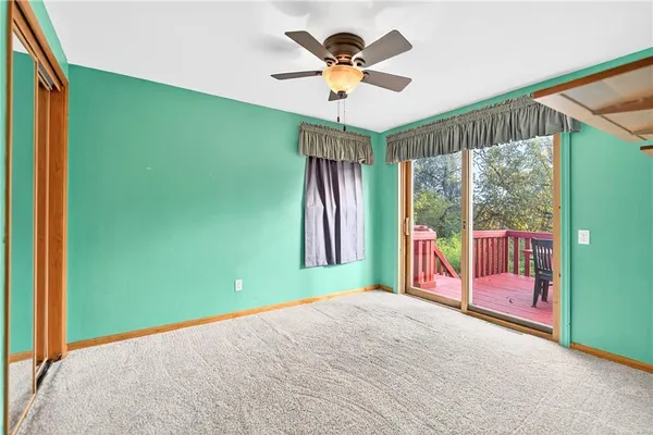 a view of empty room with a ceiling fan and a large window