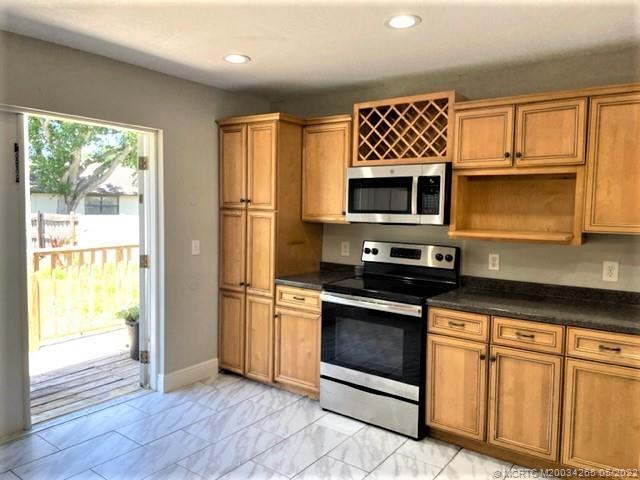 a kitchen with granite countertop a stove top oven microwave and cabinets
