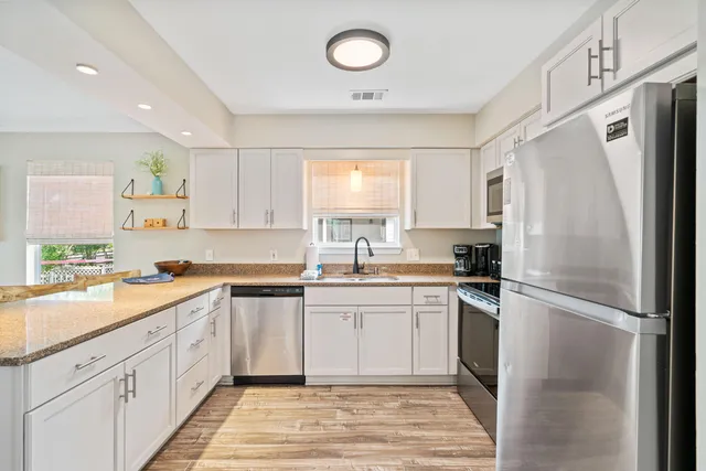 a kitchen with a refrigerator a sink and cabinets