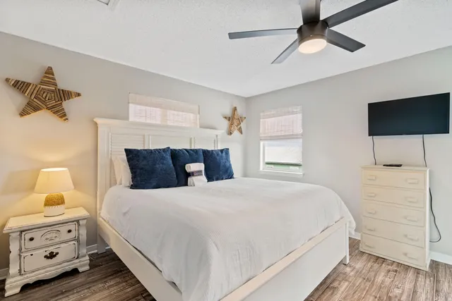 a bedroom with a bed and a flat tv screen on dresser