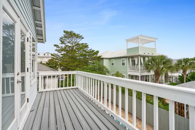 a view of a balcony with wooden floor and fence