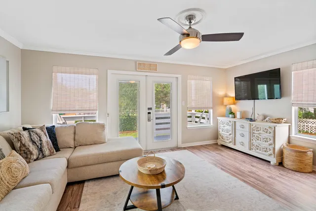 a living room with furniture a flat screen tv and a window