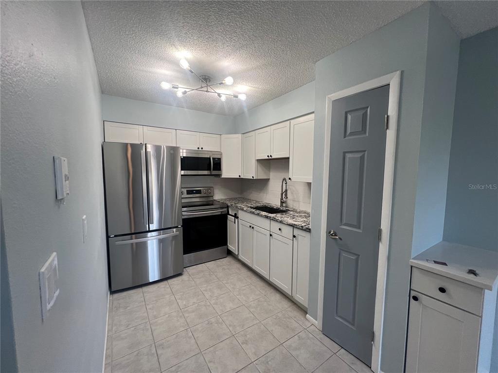 810 Kings Court, Unit D Punta Gorda, FL 33950 - Photo 4 of 10 a kitchen with stainless steel appliances granite countertop a refrigerator sink and stove