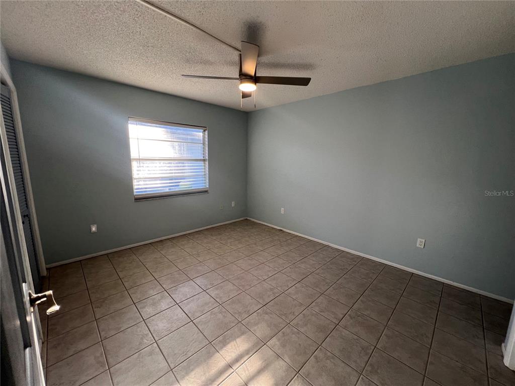 810 Kings Court, Unit D Punta Gorda, FL 33950 - Photo 5 of 10 an empty room with windows and ceiling fan