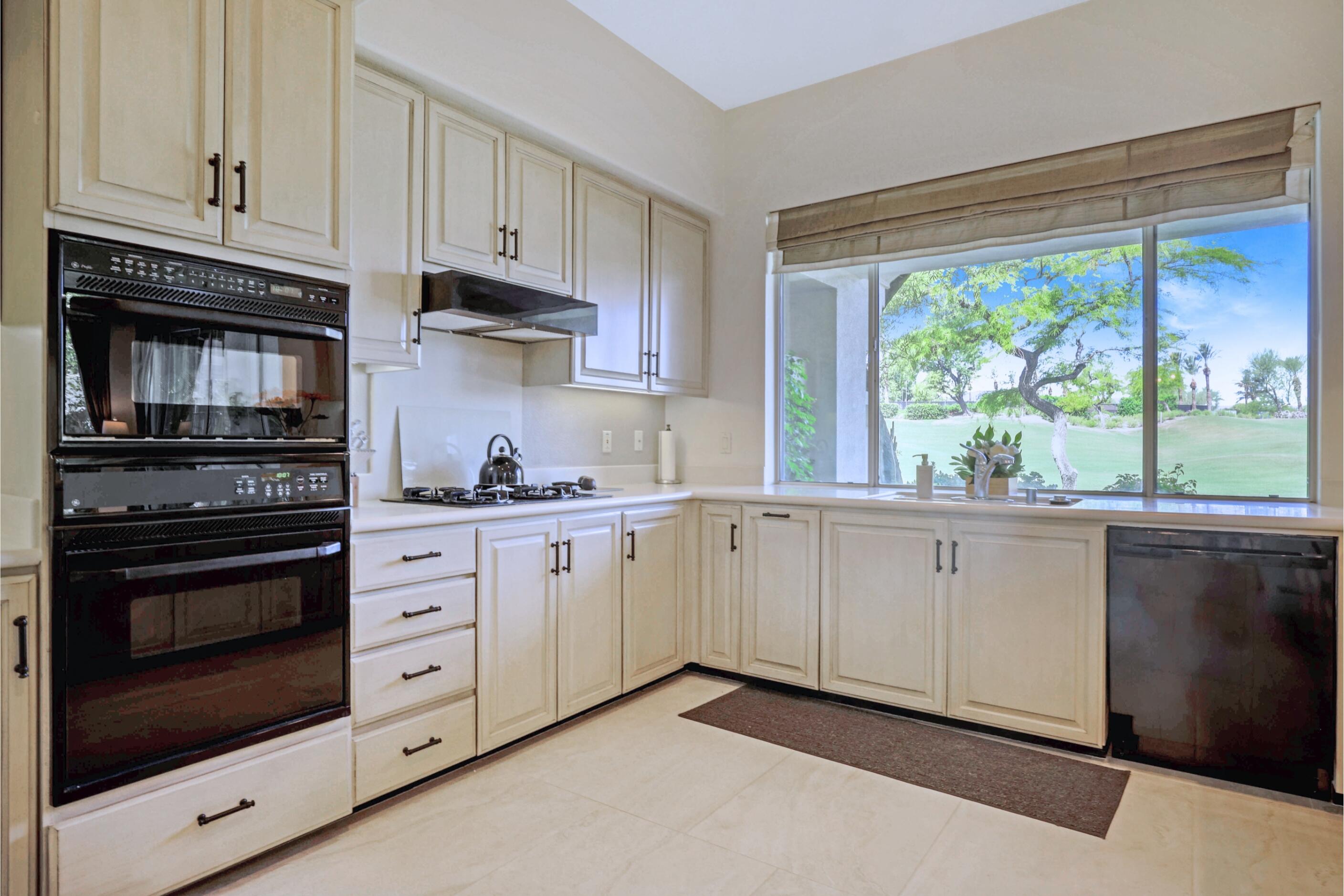 371 Indian Ridge Drive Palm Desert, CA 92211 - Photo 11 of 32 a kitchen with granite countertop white cabinets and appliances