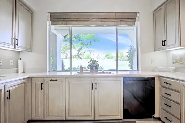a kitchen with white cabinets and refrigerator