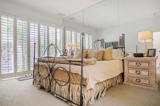 a bedroom with a bed and a flat screen tv in white walls
