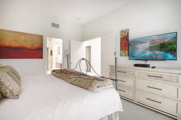 a bedroom with a bed and a potted plant