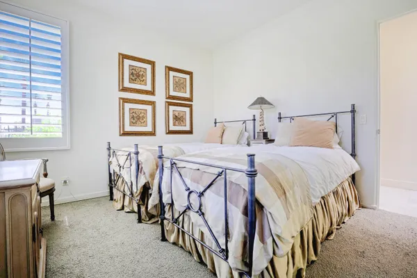 a bedroom with a bed and a large window