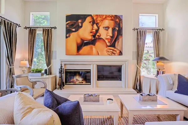a living room with furniture a fireplace and a large window