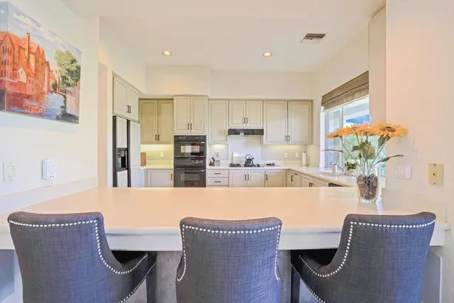 a kitchen with granite countertop white cabinets and appliances