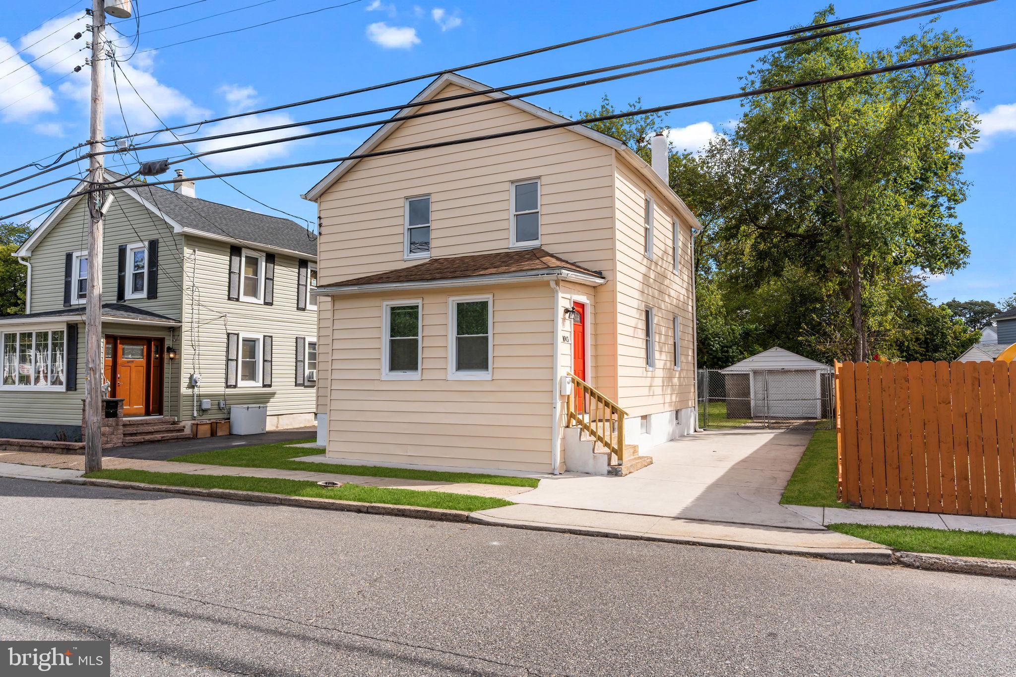 a view of a house with a small yard and wooden fence