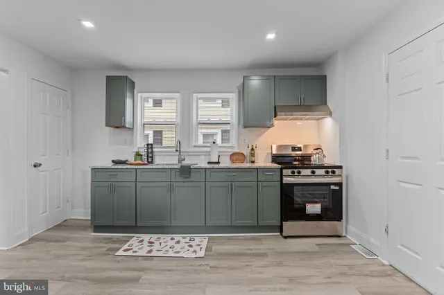 a kitchen with stainless steel appliances granite countertop a stove a sink and a refrigerator