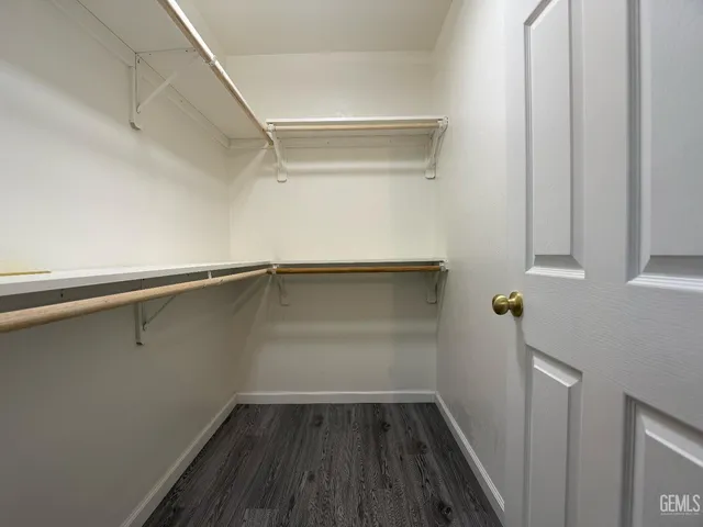 a view of storage and utility room with wooden floor and cabinet