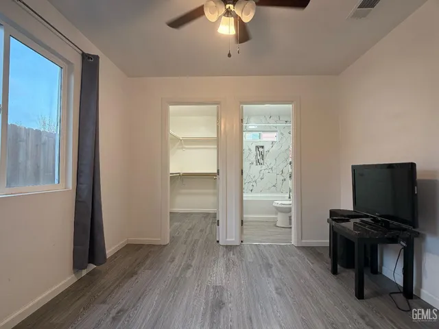a view of room with window cabinet flat screen tv and wooden floor