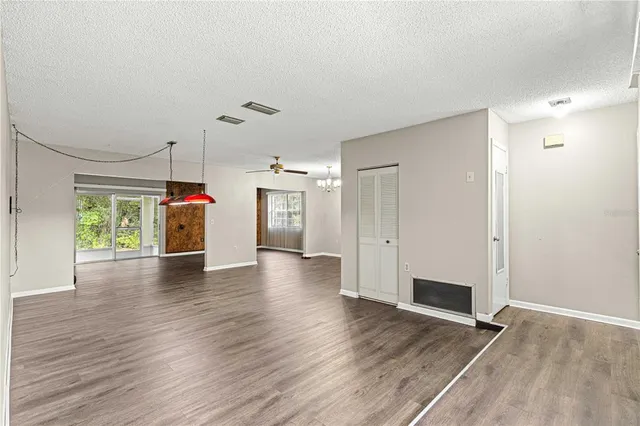 a view of a livingroom with wooden floor and a ceiling fan