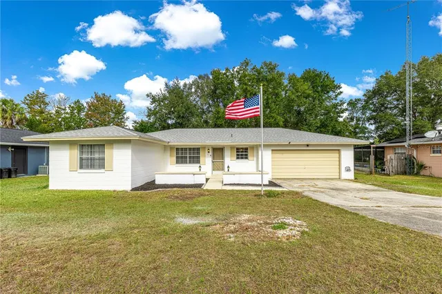 a view of a house with a backyard and swimming pool