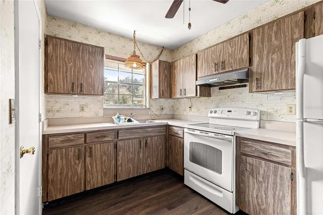 a kitchen with stainless steel appliances granite countertop a sink a stove and cabinets